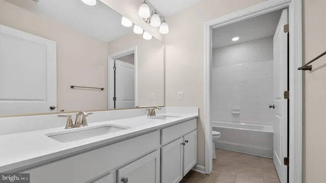 a bathroom with a sink double vanity granite tub and a mirror