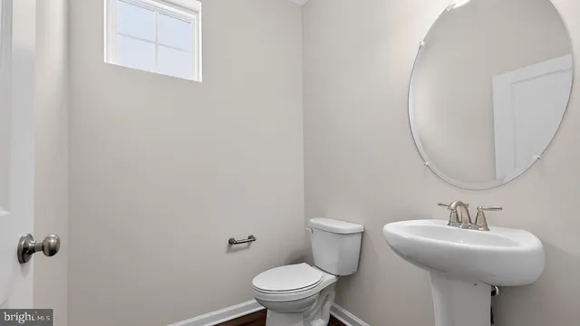 a bathroom with a sink toilet and a mirror