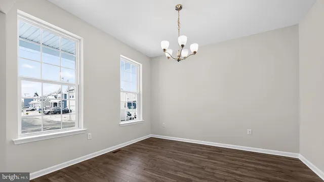 a view of empty room with wooden floor and window