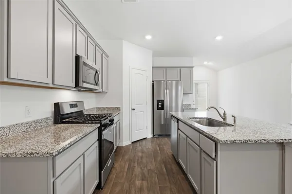 a kitchen with stainless steel appliances granite countertop a sink stove and refrigerator