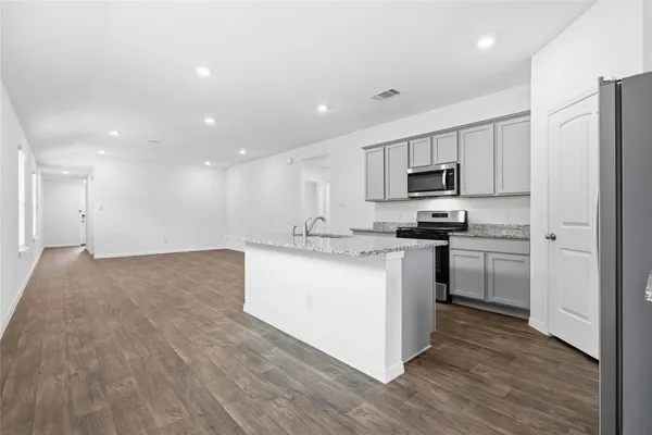 a kitchen with kitchen island a sink stainless steel appliances and cabinets