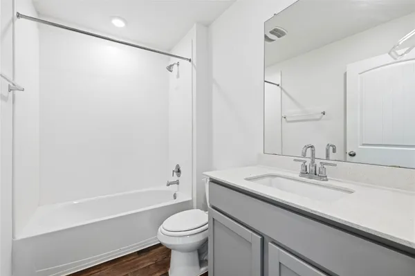 a bathroom with a sink a toilet a mirror and shower
