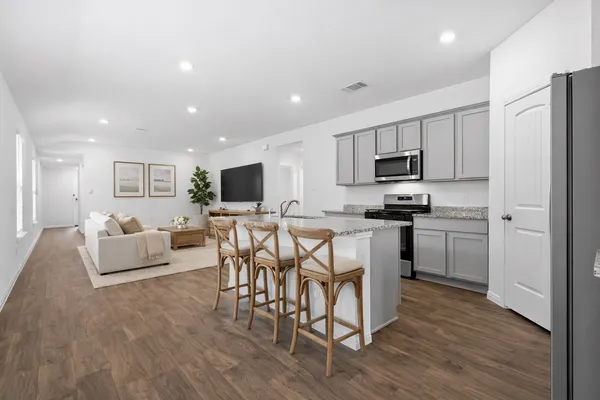 a kitchen with microwave a refrigerator and chairs