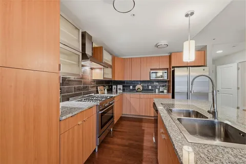 a kitchen with stainless steel appliances granite countertop a sink and a stove