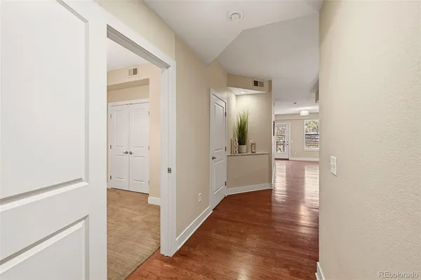 a view of a hallway with wooden floor