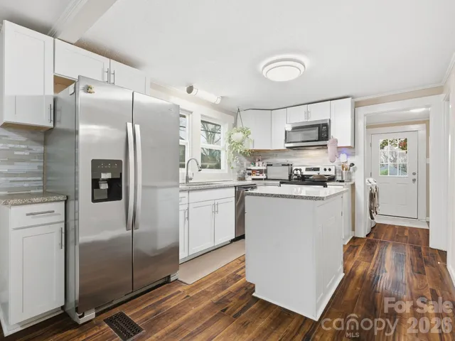 a kitchen with a refrigerator a sink and cabinets