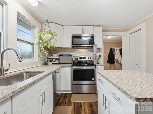 a kitchen with kitchen island granite countertop a sink stainless steel appliances and cabinets