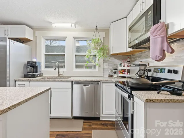 a kitchen with stainless steel appliances granite countertop a stove and a sink