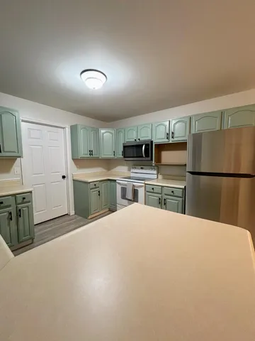 a large kitchen with cabinets and stainless steel appliances