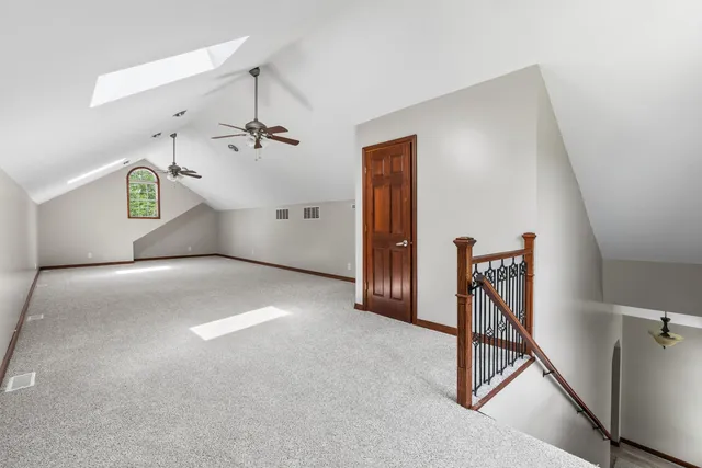 a view of a livingroom with a ceiling fan and staircase