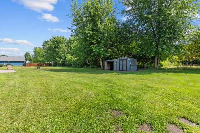 a backyard of a house with table and chairs