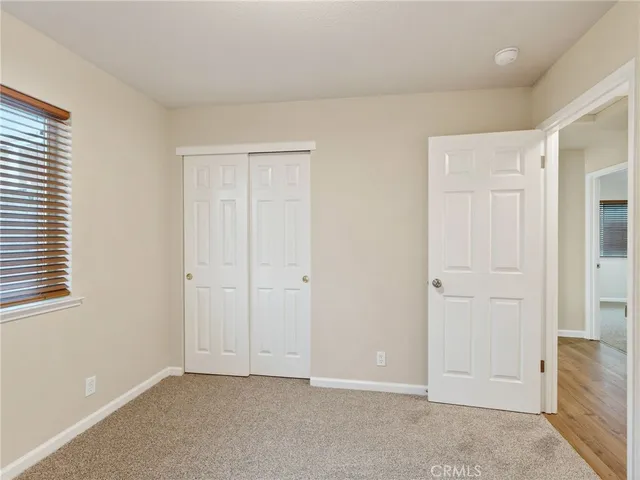 an empty room with windows and closet