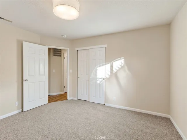 an empty room with windows and closet