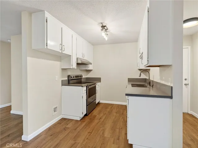 a kitchen with granite countertop a sink and a stove top oven