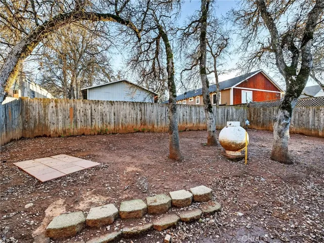 a view of a backyard with table and chairs and wooden fence