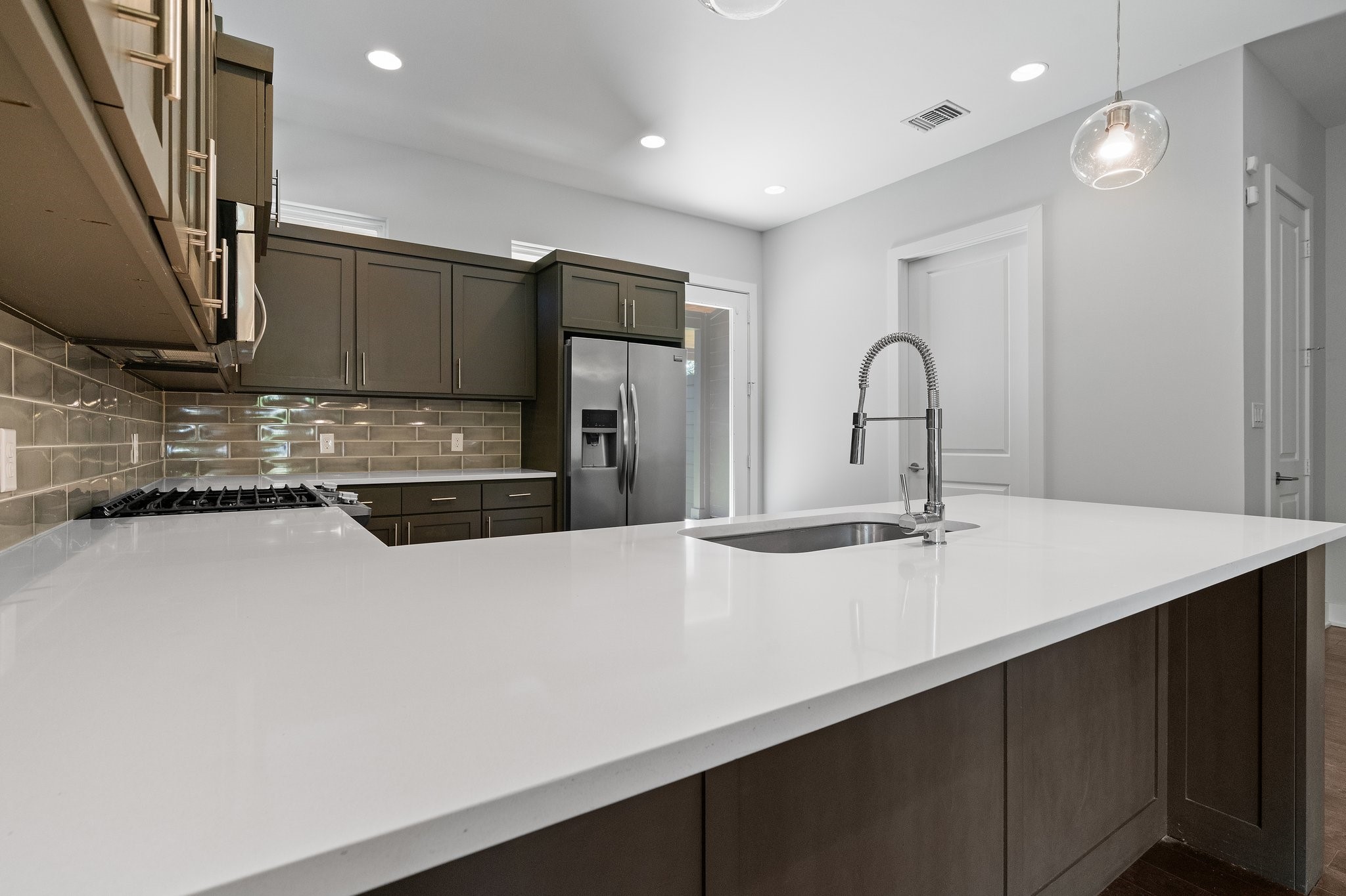 7217 Blessing Avenue, Unit A Austin, TX 78752 - Photo 3 of 22 Sleek kitchen with expansive quartz countertop and center island. Gas stove, stainless steel appliance. Incredible natural light from upper windows.