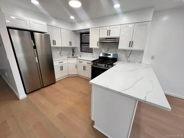 a kitchen with white cabinets and refrigerator