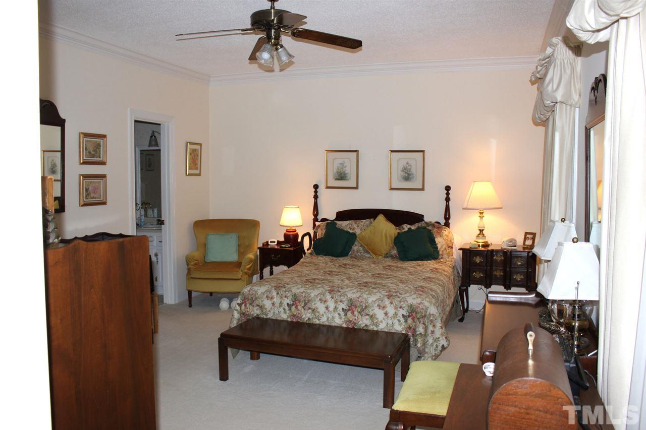 7920 Footman Way Raleigh, NC 27615 - Photo 14 of 25 a bedroom with a bed lamps and a mirror