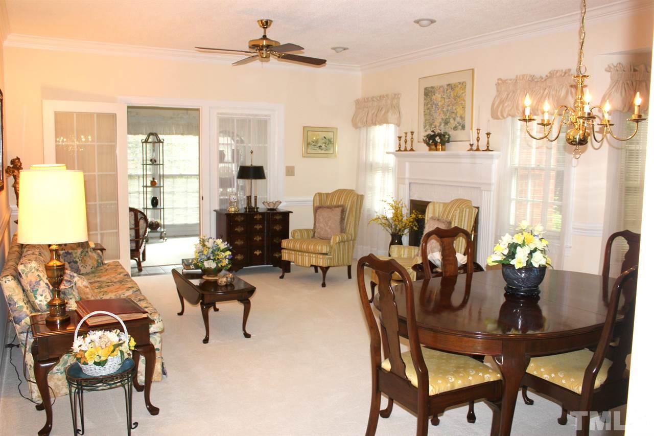7920 Footman Way Raleigh, NC 27615 - Photo 3 of 25 a living room with furniture a fireplace and a chandelier
