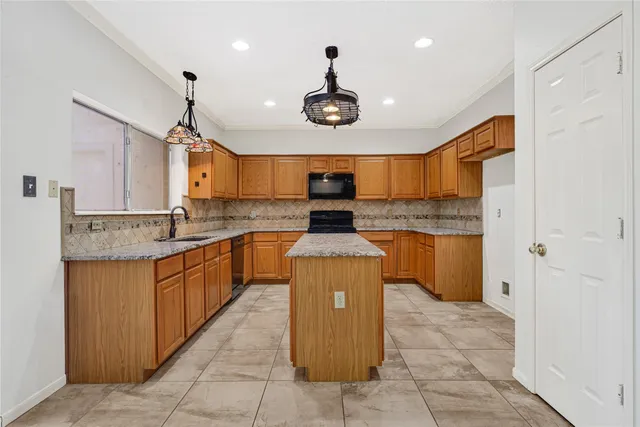 a kitchen with stainless steel appliances granite countertop a sink counter space cabinets and a chandelier