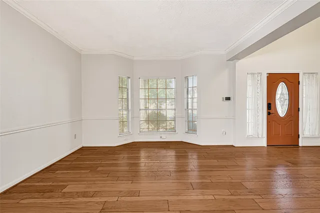 a view of an empty room with wooden floor