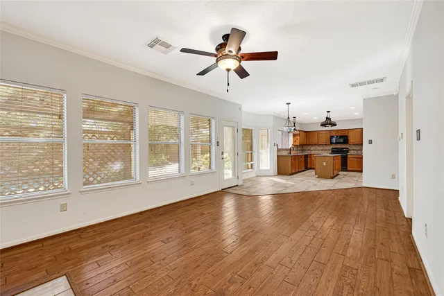 a view of a kitchen with a sink stainless steel appliances cabinets and a dining table