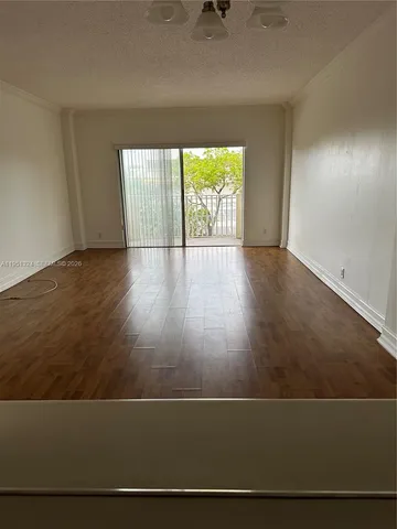 en empty room with wooden floor and windows