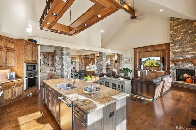 a kitchen with stainless steel appliances granite countertop a table chairs and a refrigerator