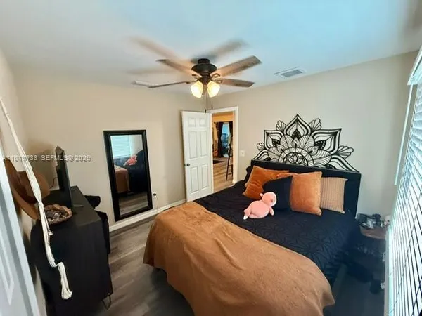 a bedroom with a bed and wooden floor