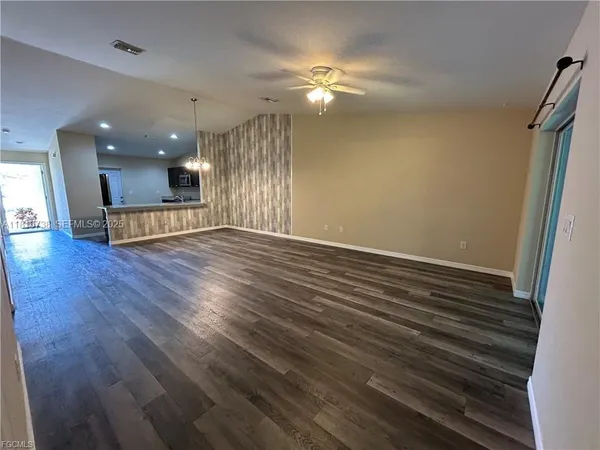 an empty room with wooden floor and door