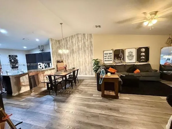 a living room with furniture a dining table and kitchen view