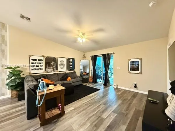 a living room with furniture and wooden floor