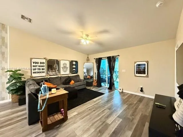 a living room with furniture and wooden floor