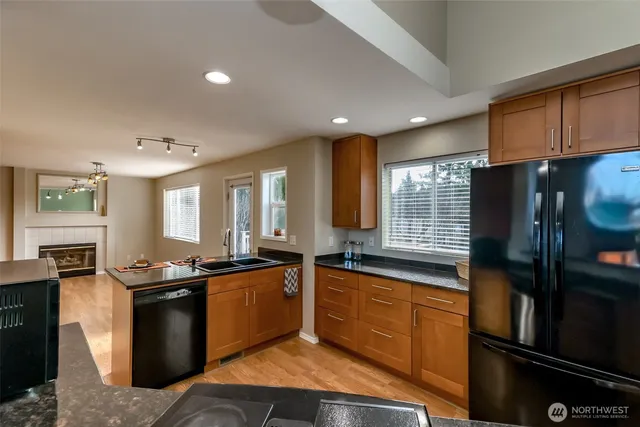 a kitchen with granite countertop a sink stove and refrigerator