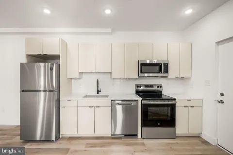 a kitchen with white cabinets and stainless steel appliances
