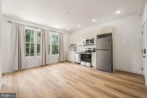 a kitchen with stainless steel appliances a refrigerator and wooden floor