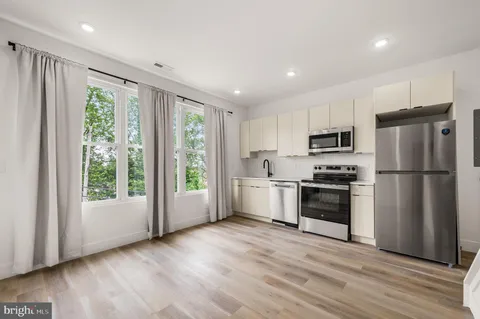a kitchen with a refrigerator a sink and a stove top oven