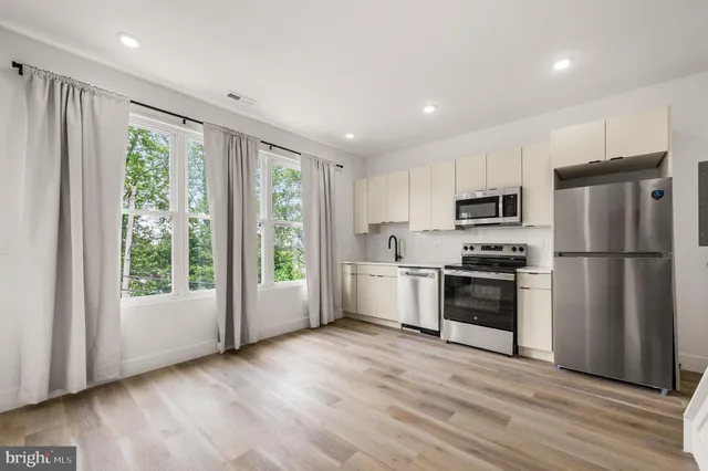 a kitchen with a refrigerator a sink and a stove top oven