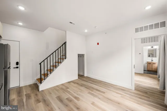 a view of a hallway with wooden floor and staircase