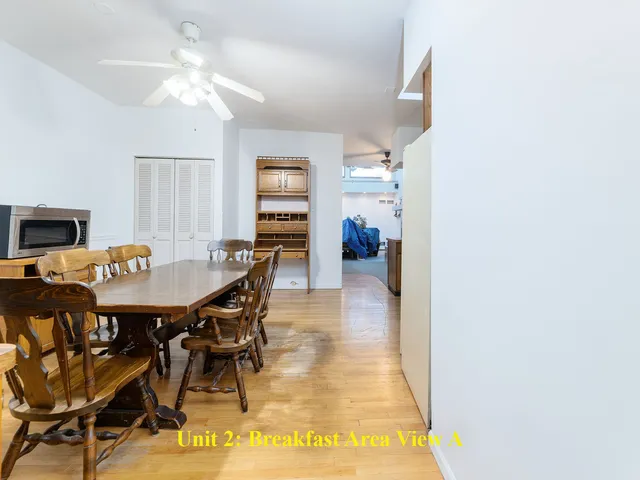 a kitchen with granite countertop a stove top oven a sink dishwasher and a refrigerator with wooden floor