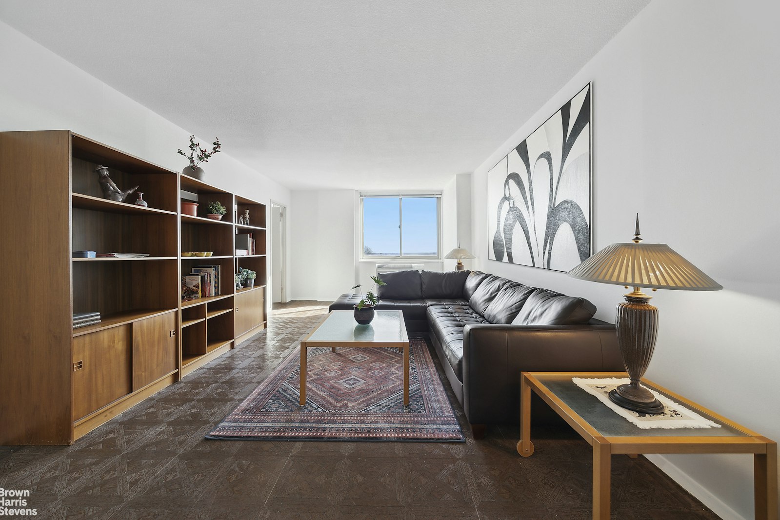 a living room with furniture a rug and a bookshelf