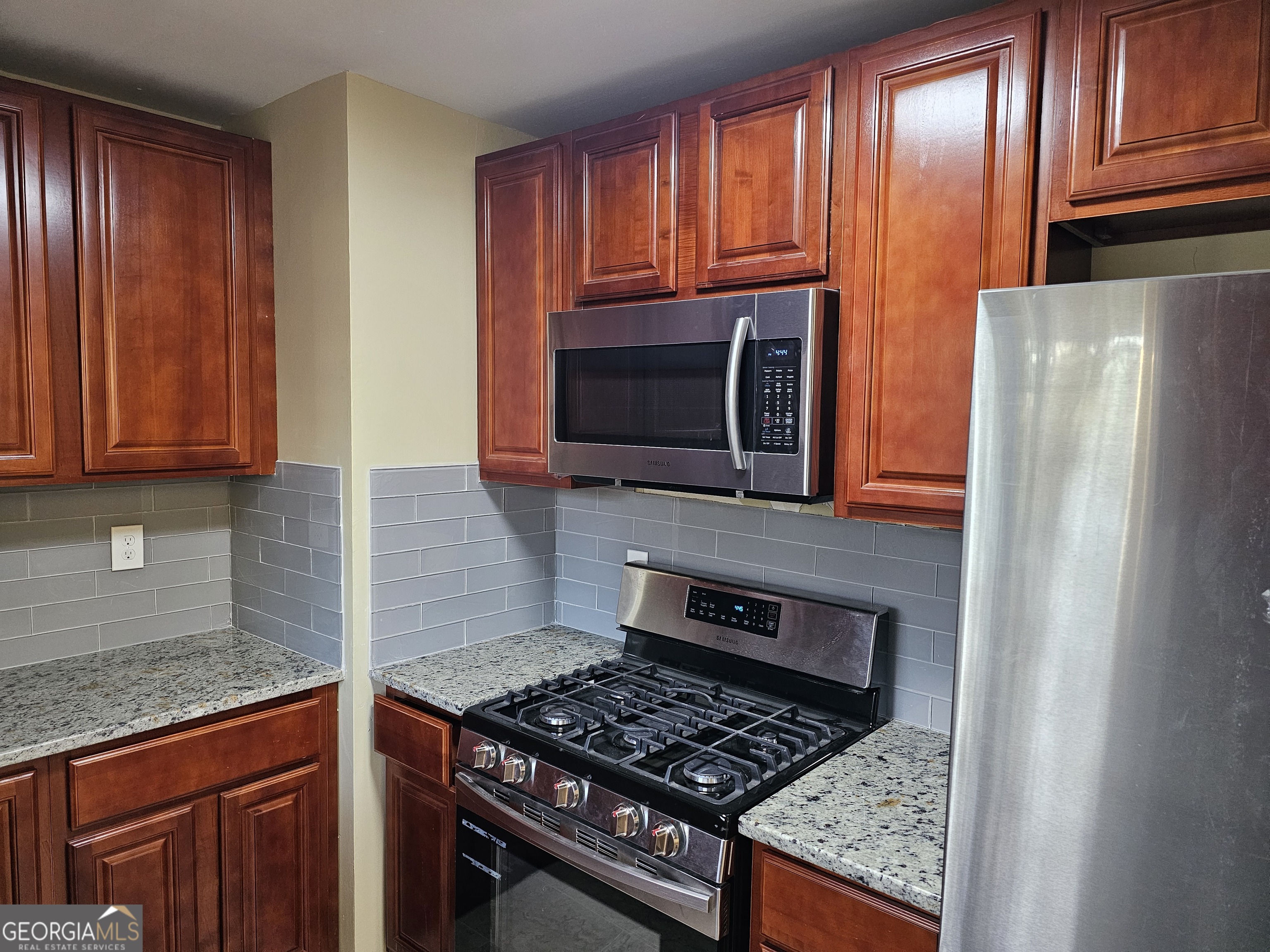 655 Shellnut Drive Forest Park, GA 30297 - Photo 11 of 31 a kitchen with granite countertop stainless steel appliances and wooden cabinets