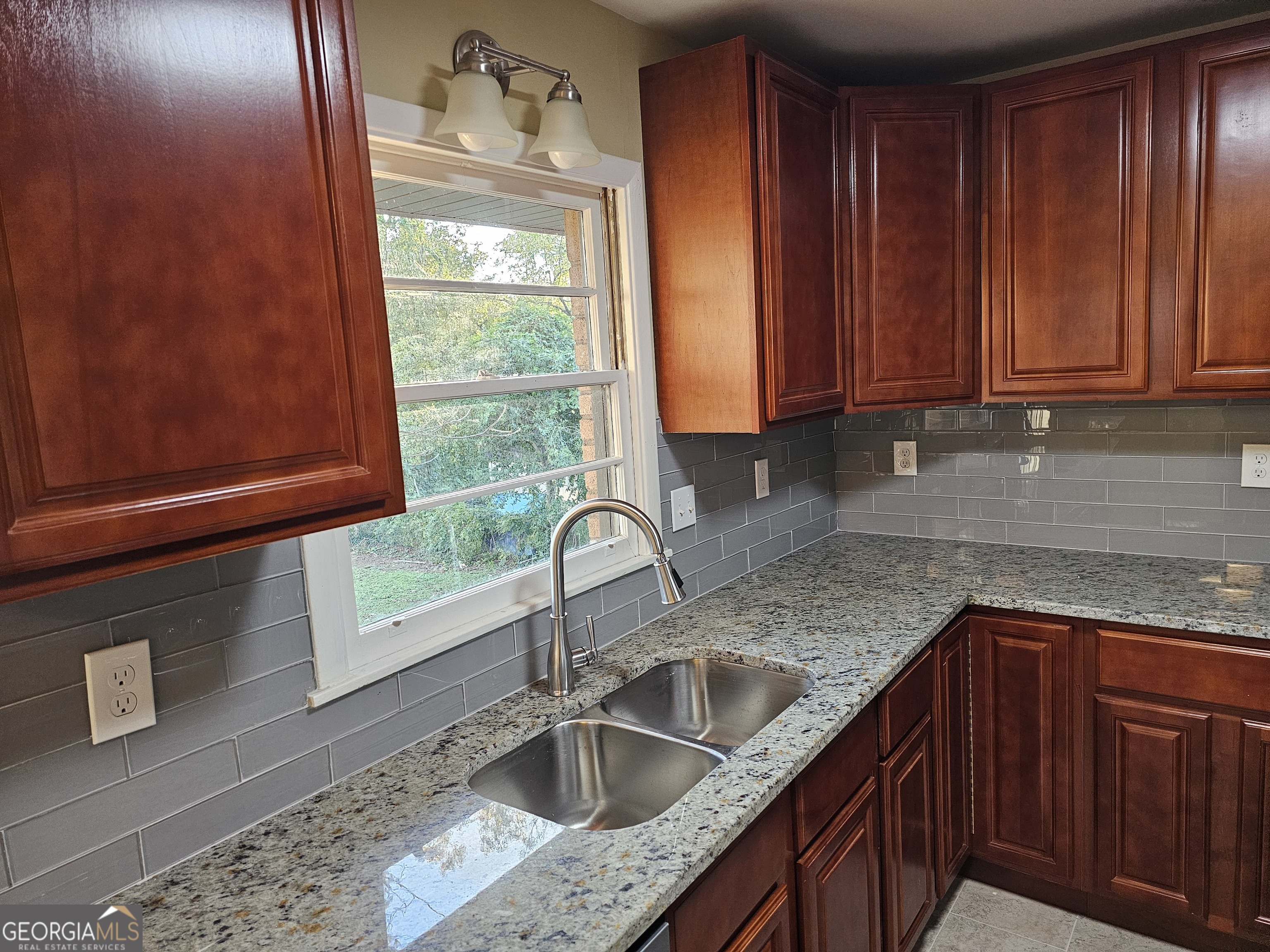 655 Shellnut Drive Forest Park, GA 30297 - Photo 12 of 31 a kitchen with granite countertop wooden cabinets a sink and dishwasher