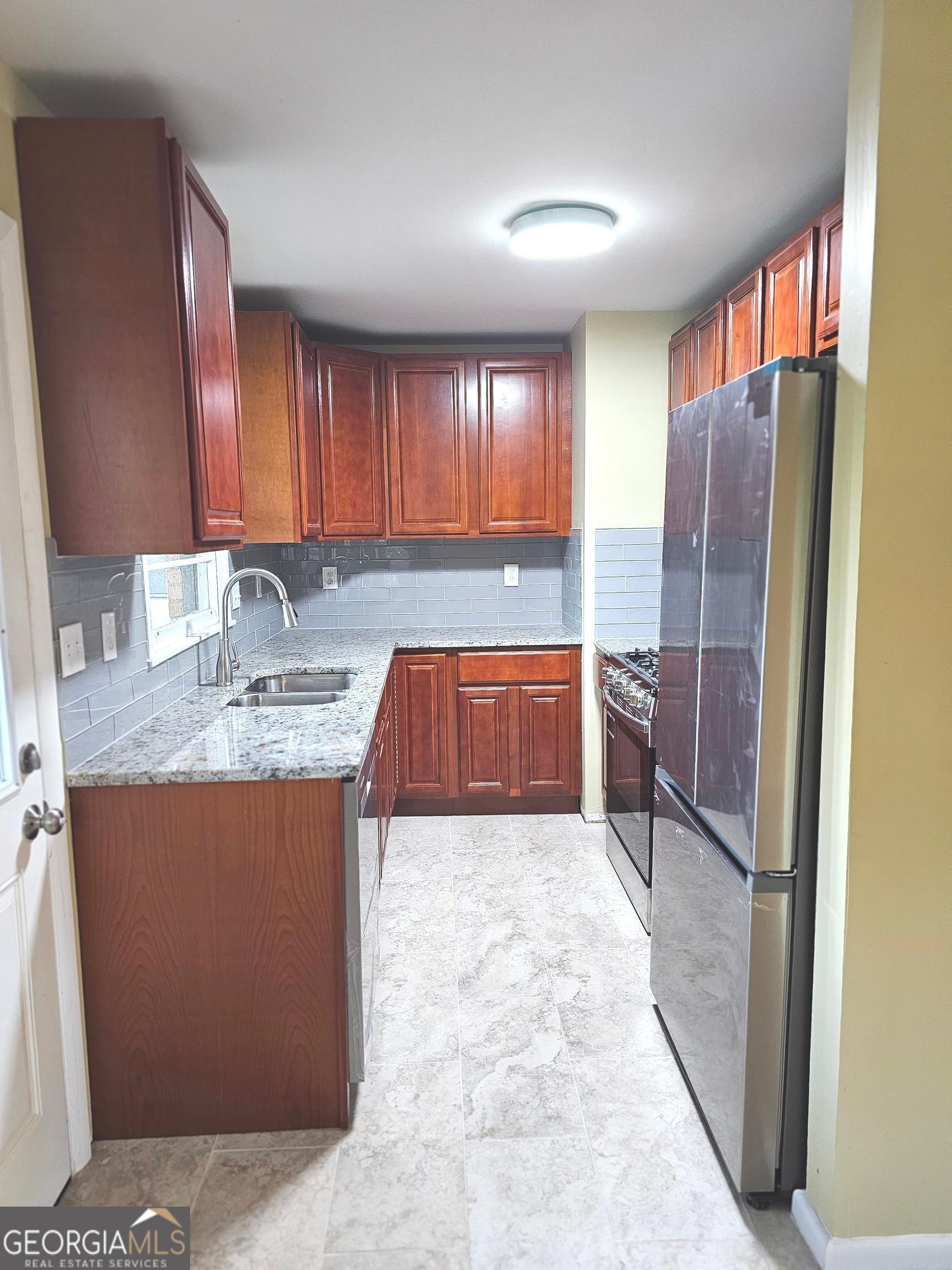 655 Shellnut Drive Forest Park, GA 30297 - Photo 16 of 31 a kitchen with granite countertop a refrigerator and cabinets