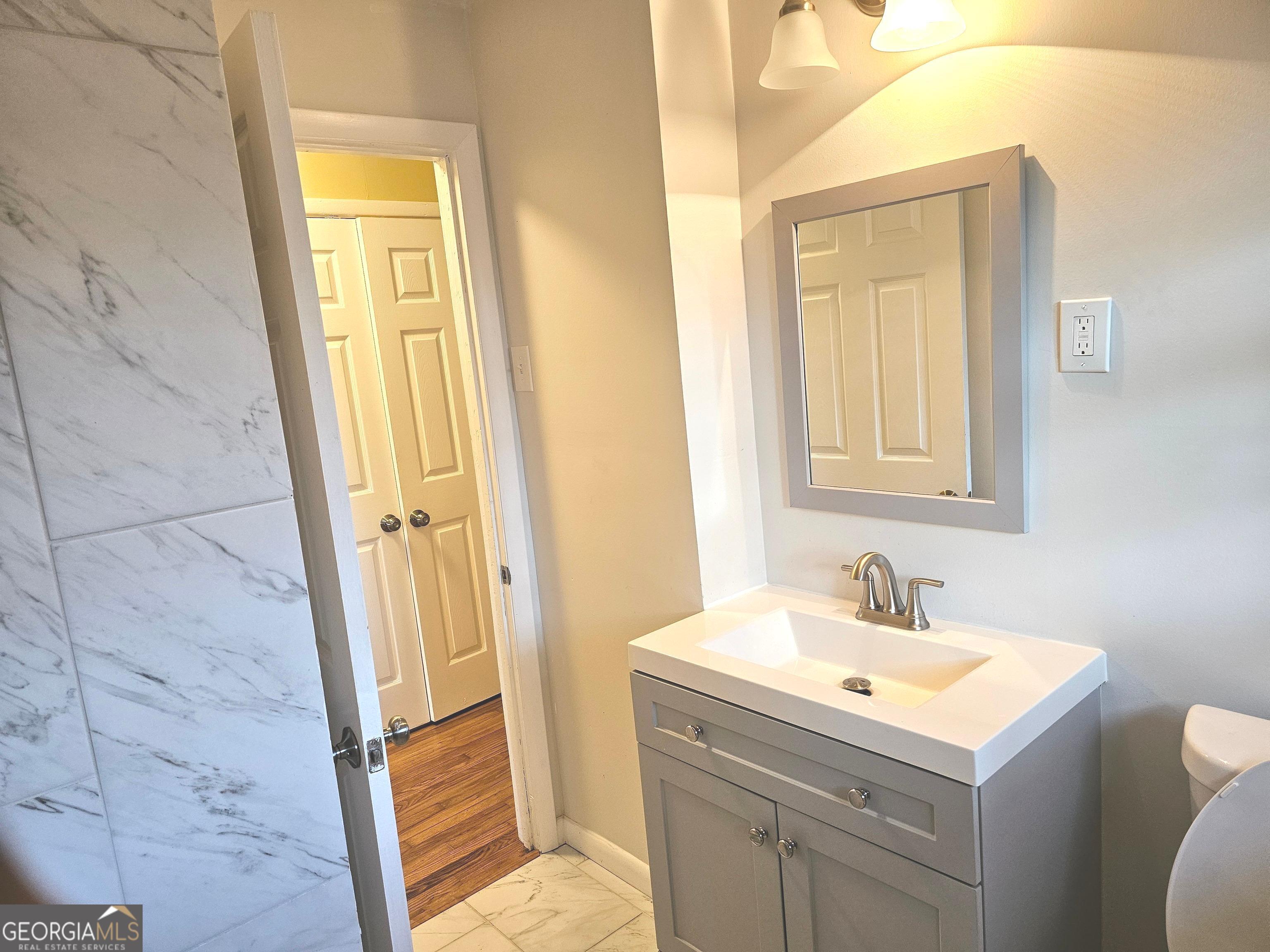 655 Shellnut Drive Forest Park, GA 30297 - Photo 20 of 31 a bathroom with a sink a mirror and a toilet