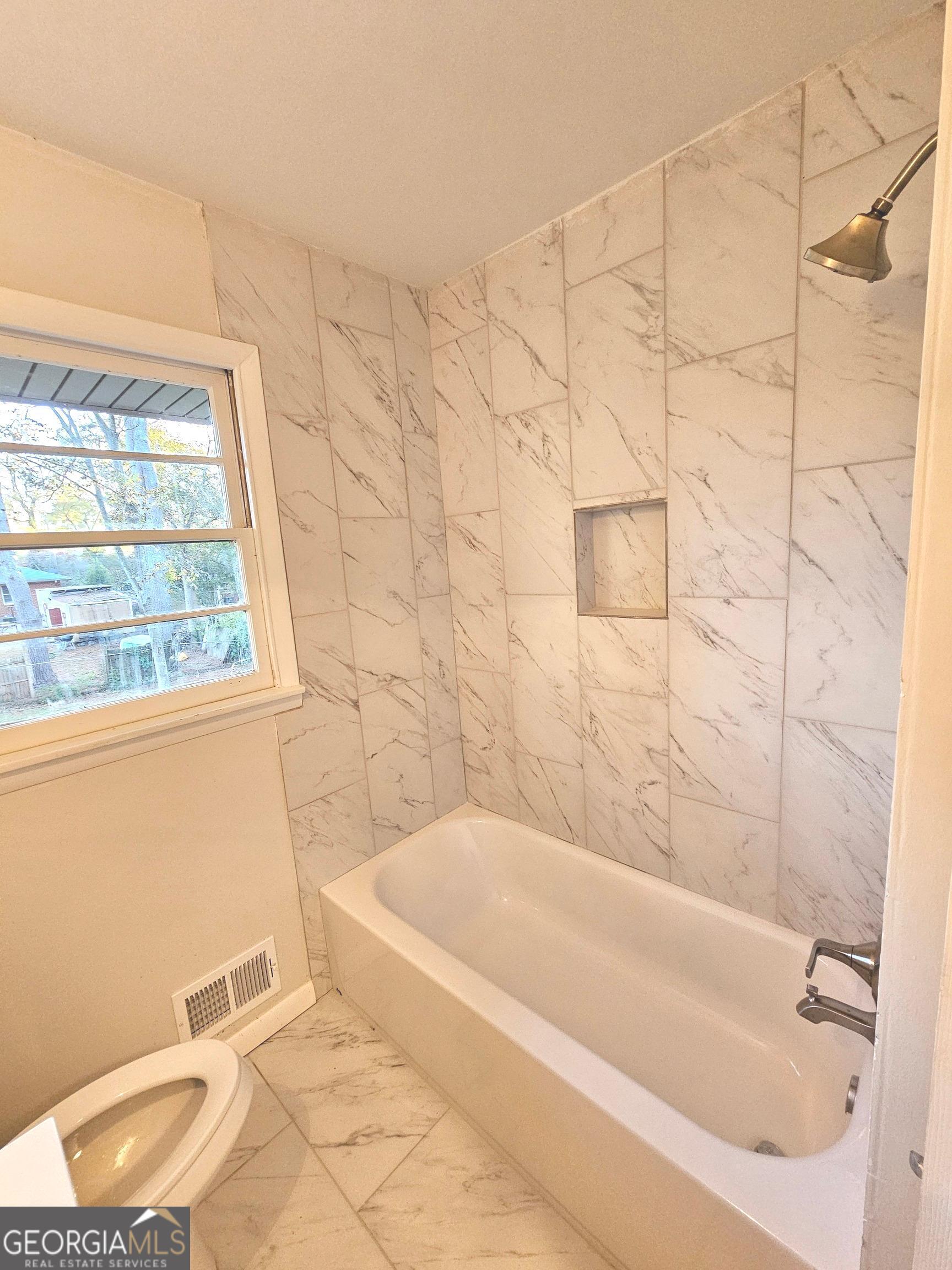 655 Shellnut Drive Forest Park, GA 30297 - Photo 23 of 31 a bath tub sitting next to a white toilet and a shower