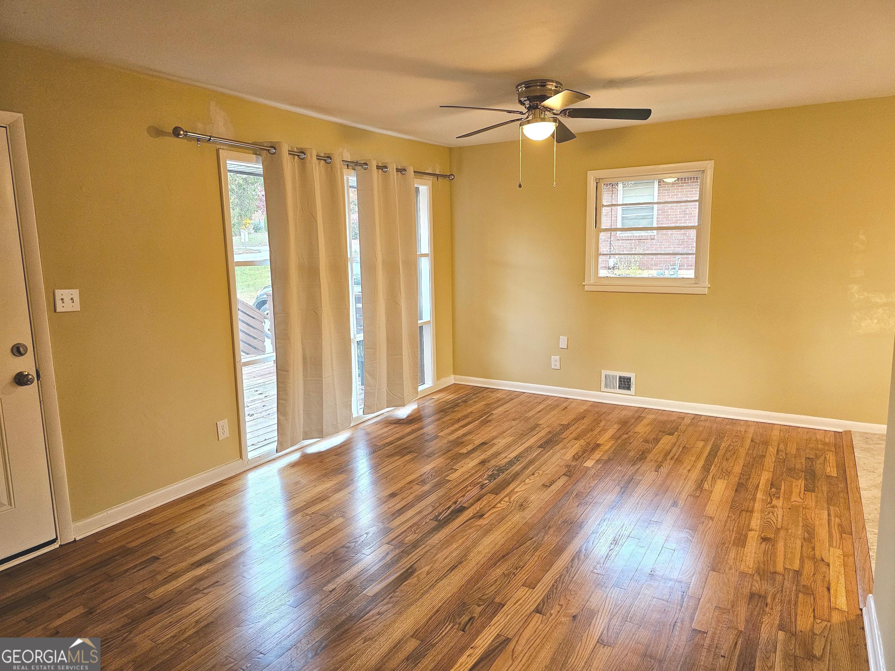655 Shellnut Drive Forest Park, GA 30297 - Photo 4 of 31 a view of an empty room with a window and wooden floor