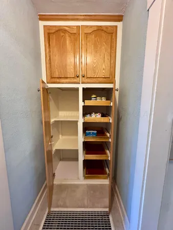 a walk in closet with wooden floor