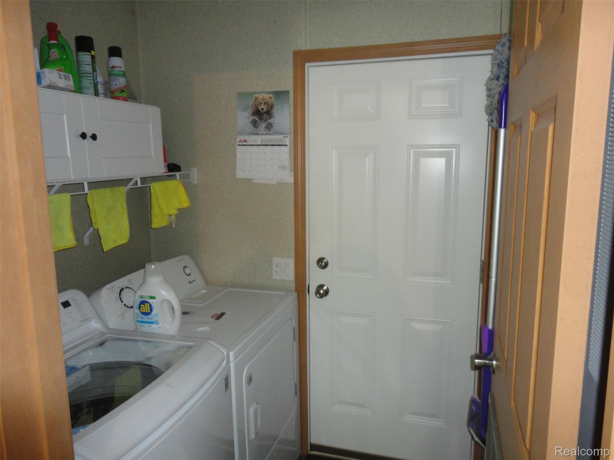 463 Edinborough Temperance, MI 48182 - Photo 6 of 23 Laundry area featuring a paneled door, built-in wall cabinet, and a wall-mounted shelving unit