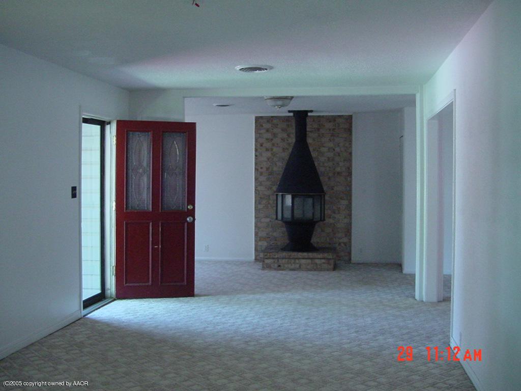 4007 Cline Road Amarillo, TX 79110 - Photo 3 of 11 an empty room with a fireplace and baby crib